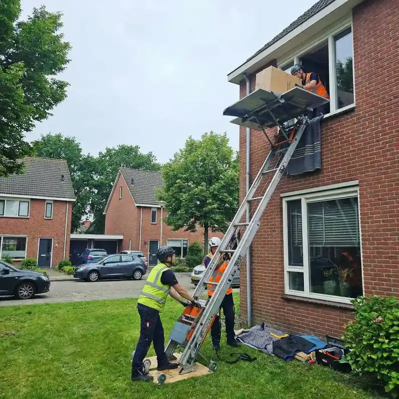 Twee monteurs zetten een GEDA opbouwlift klaar in een rustige woonwijk