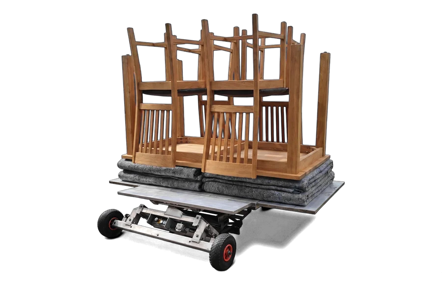 Eettafel met stoelen op het ruime plateau van de verhuislift onderweg naar de woning
