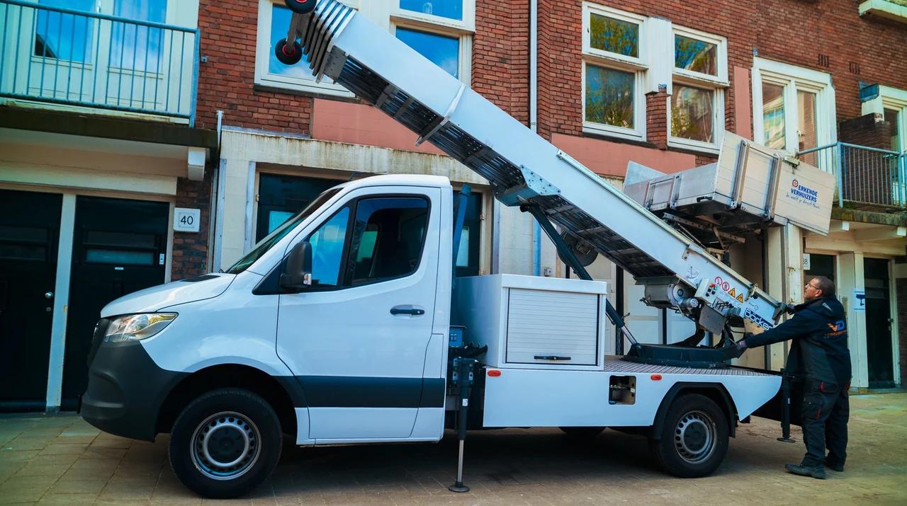 Witte verhuislift bij een bakstenen gevel